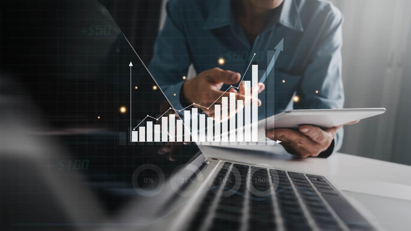 Business investor analyzing business intelligence (BI) with key performance indicators (KPI), profit increase, using tablet and laptop.