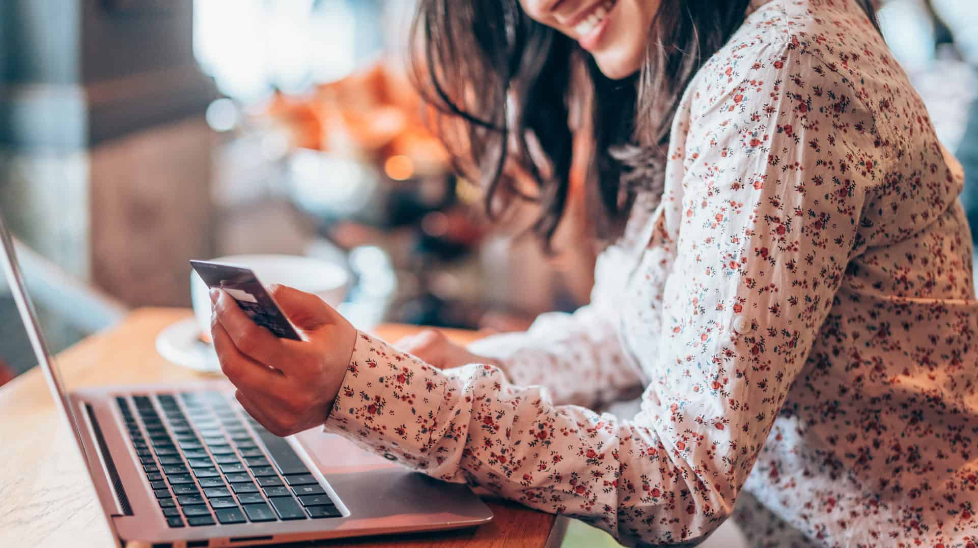 cropped-photo-of-woman-smiling-while-entering-credit-card-information-into-laptop-for-online-shopping-while-seated