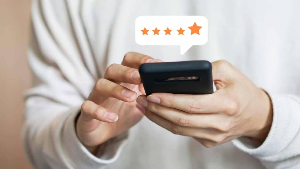 person-holding-smartphone-with-five-star-review-bubble-above-phone-word-of-mouth-marketing-concept