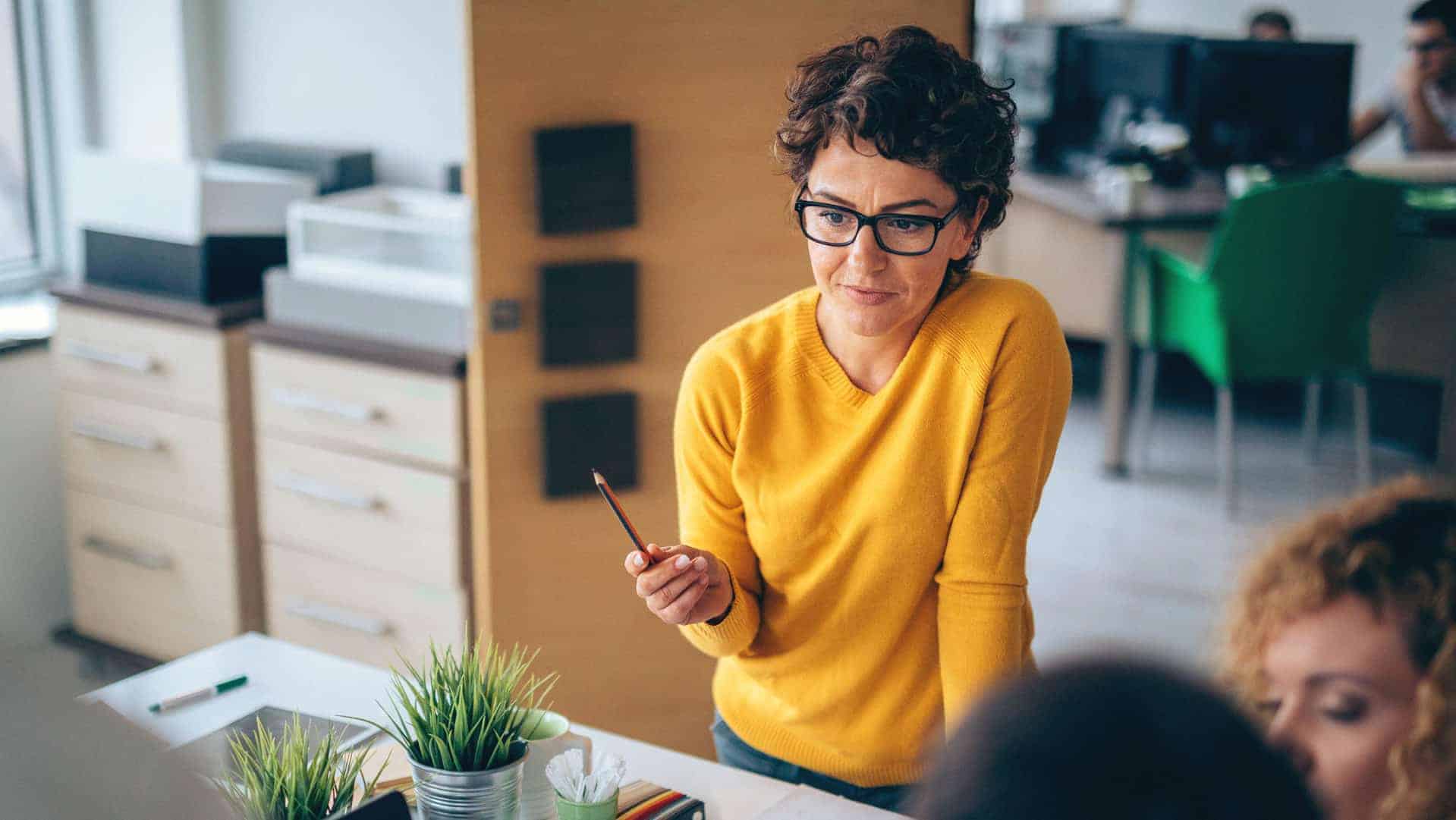 woman-giving-informal-presentation-about-digital-marketing-myths-in-office-with-desks-and-filing-cabinets-in-background